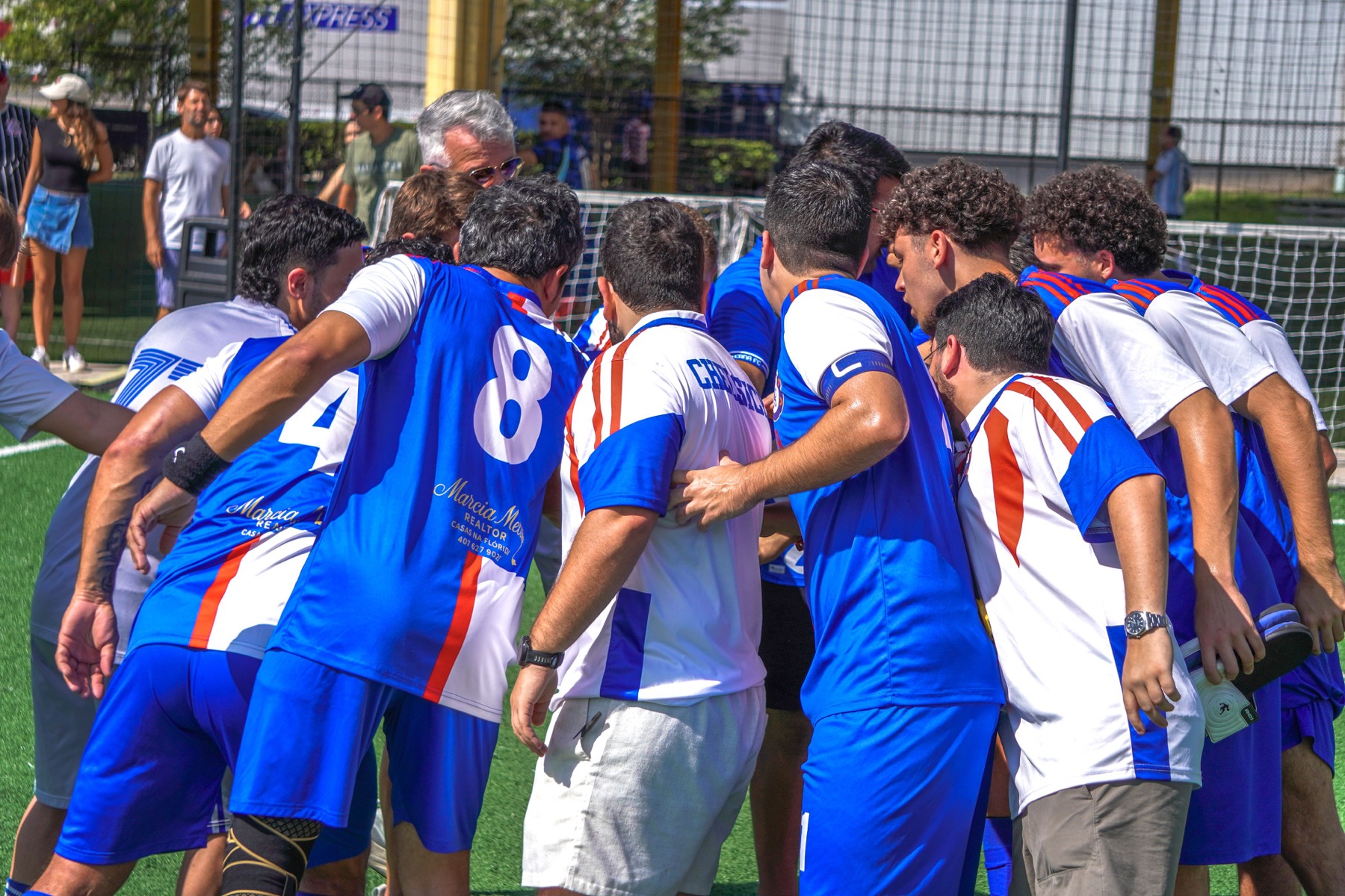 Chelsicha FC players gathered in a pre-match huddle